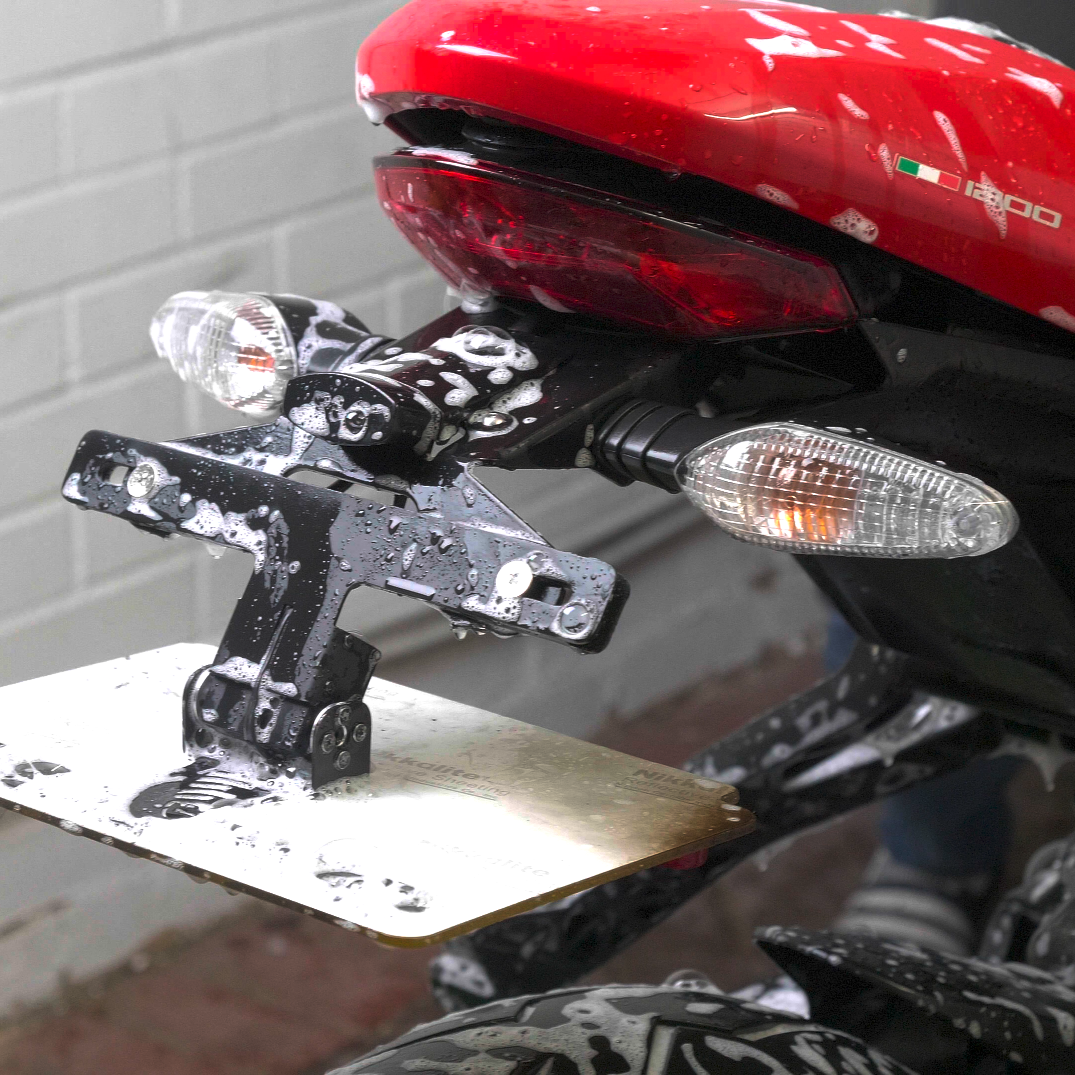 Close-up of a motorcycle's rear lights and electric license plate flipper.